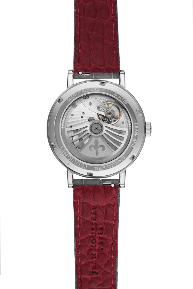 The caseback of a Pequignet Attitude Tiger’s Eye Limited Edition watch with a red leather strap 
