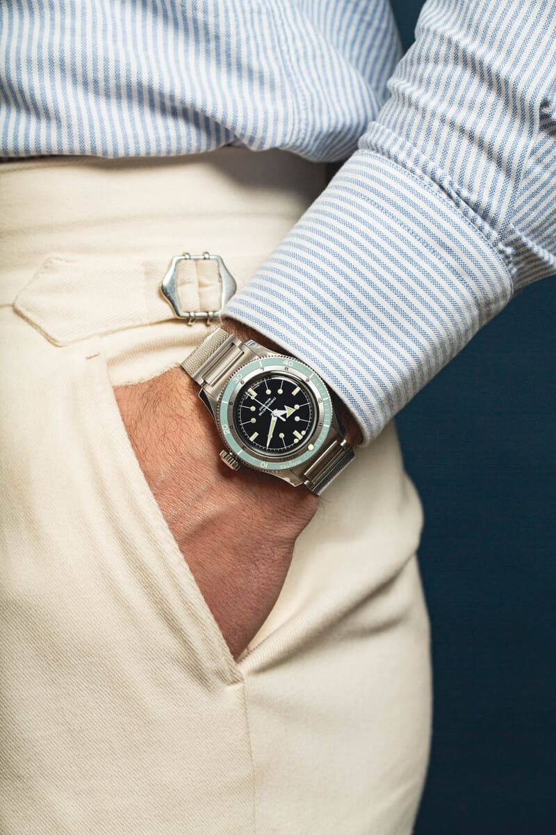 Serica 5303 watch worn on mans wrist with his hand in his pocket
